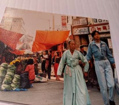 Street scene in Korea we people in traditional and modern clothing.