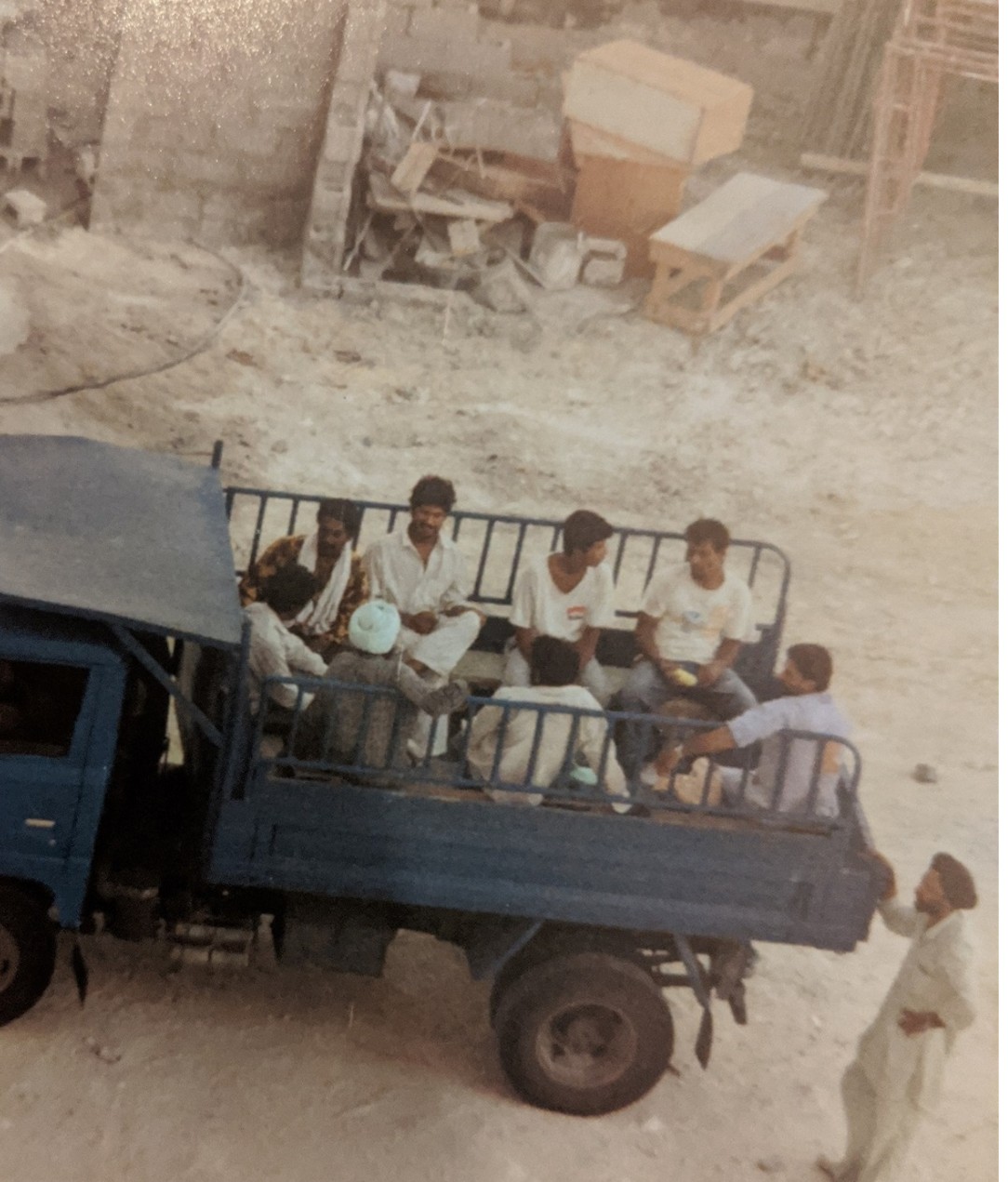 Construction workers on the back of a truck