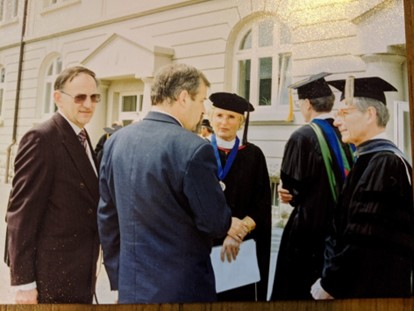 Teachers with students wearing graduation outfits.